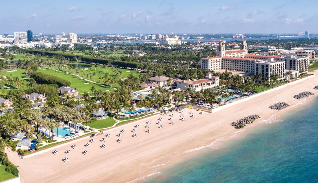 a beach with palm trees and palm trees at The Breakers Palm Beach in Palm Beach