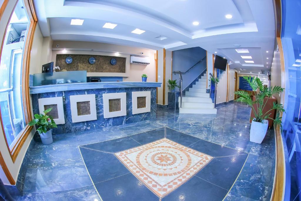 a lobby with a blue tile floor and a counter at Hotel Vicentina in Boca Chica