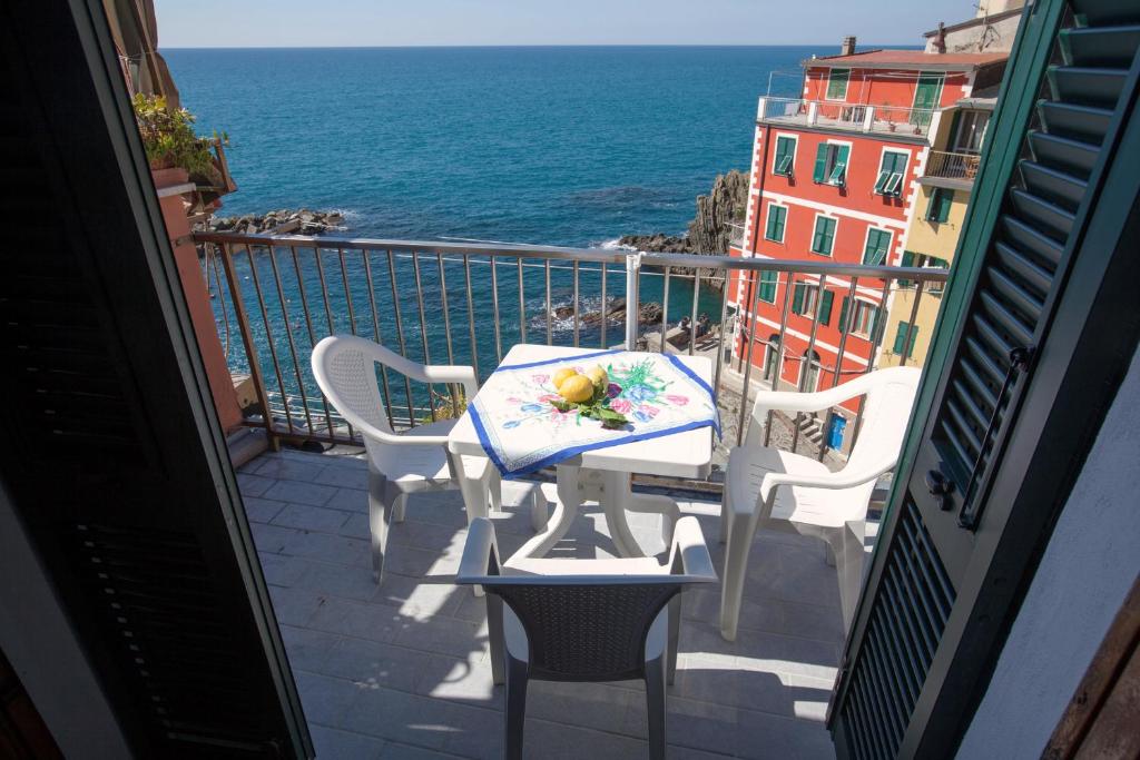 balcón con mesa, sillas y vistas al océano en L'ORIZZONTE, en Riomaggiore