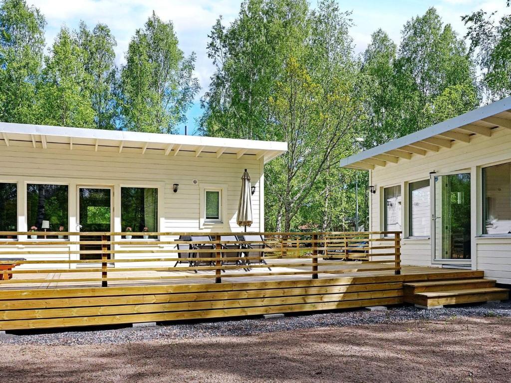 une maison avec une grande terrasse en bois devant elle dans l'établissement 6 person holiday home in LOFTAHAMMAR, à Loftahammar