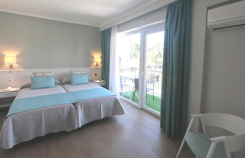 a bedroom with a bed and a large window at Hotel Creta Paguera in Paguera