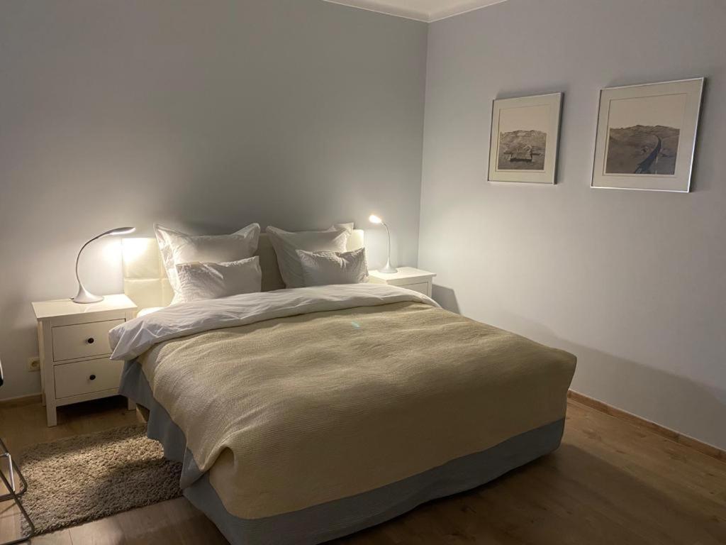 1 dormitorio blanco con 1 cama grande y 2 lámparas en Spacious studio en Knokke-Heist