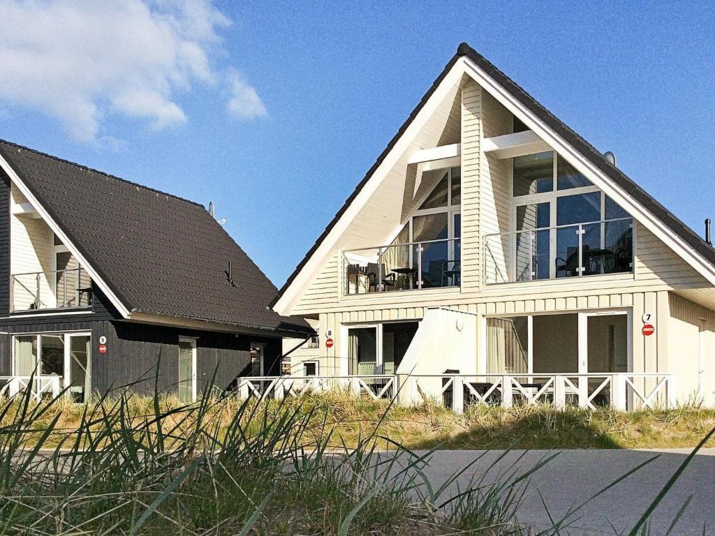 a large white house with a black roof at Holiday Home Strandblick IV in Wendtorf