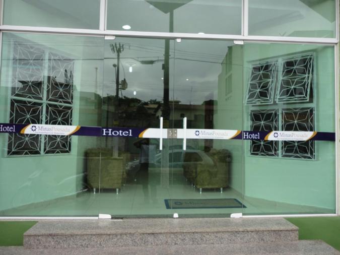 uma janela de vidro de um hotel com placas em HF Minas Hotel em Vespasiano
