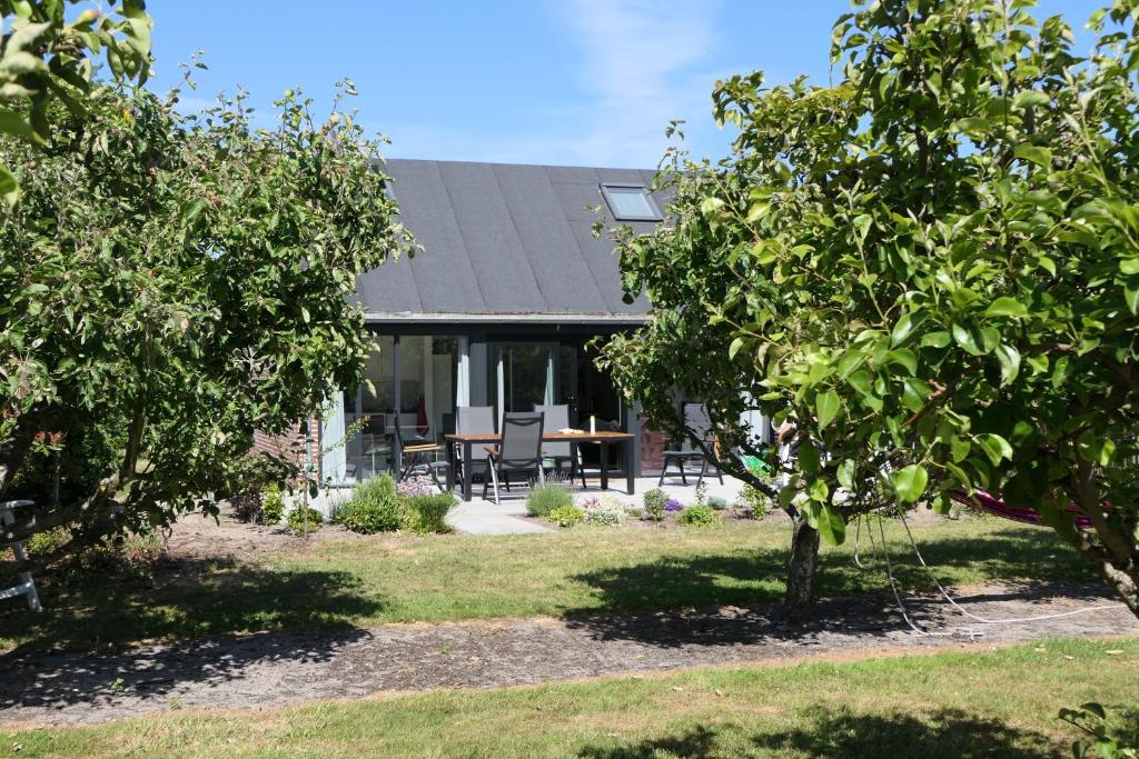 uma casa com árvores em frente em Buitenplaats Schouwen em Burgh Haamstede