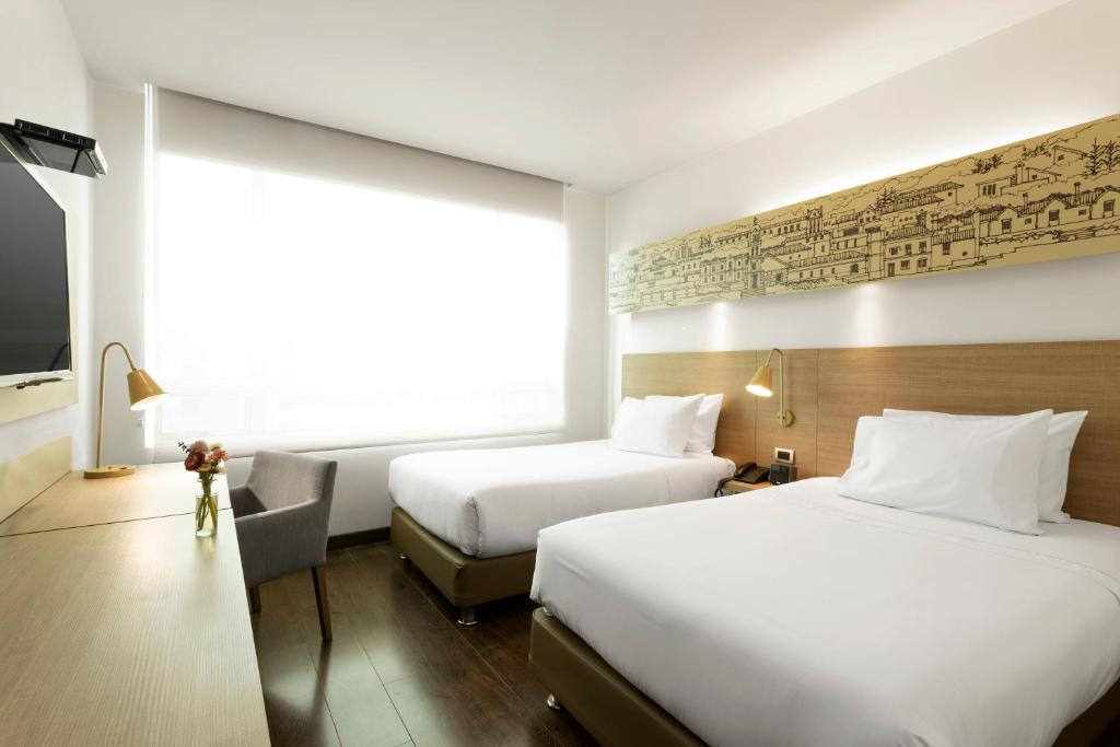 Postel nebo postele na pokoji v ubytování Hotel bh Usaquén