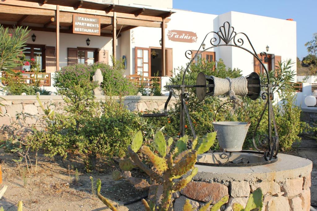a water fountain in a garden in front of a building at Galini in Agia Irini Milos