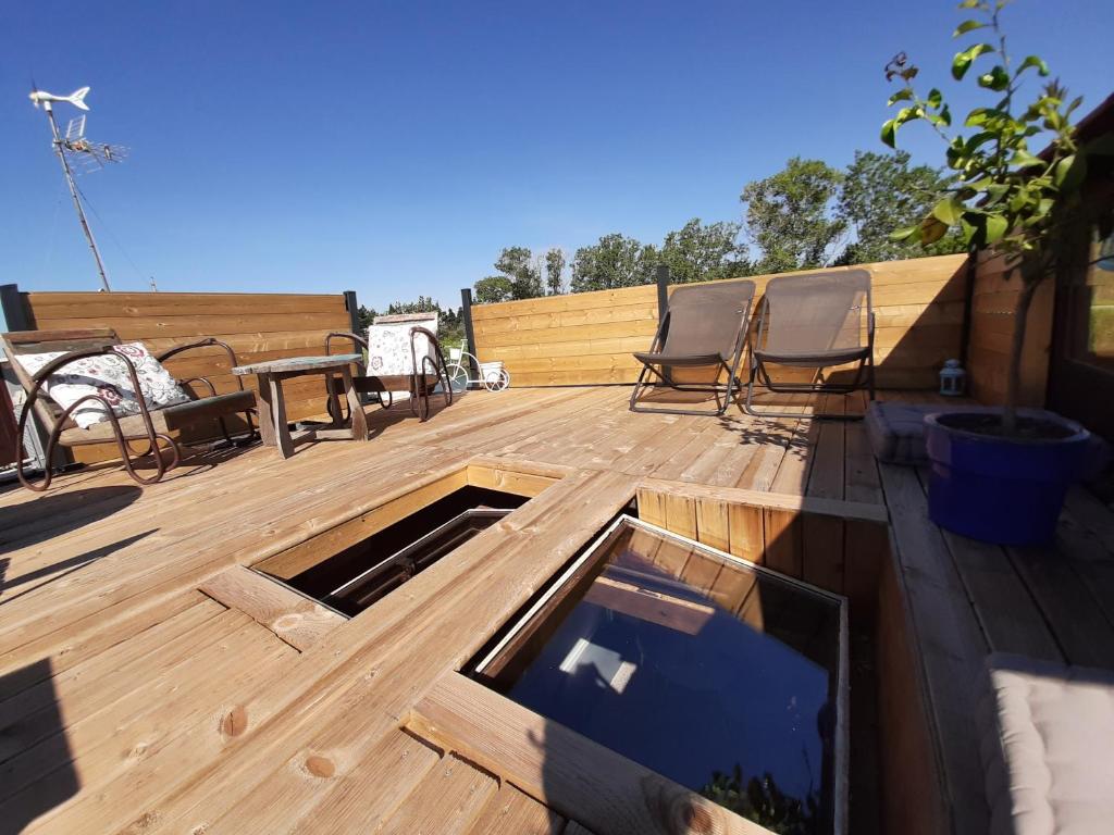 a wooden deck with two chairs and a table at Péniche La Belle Aimée in Aigues-Mortes