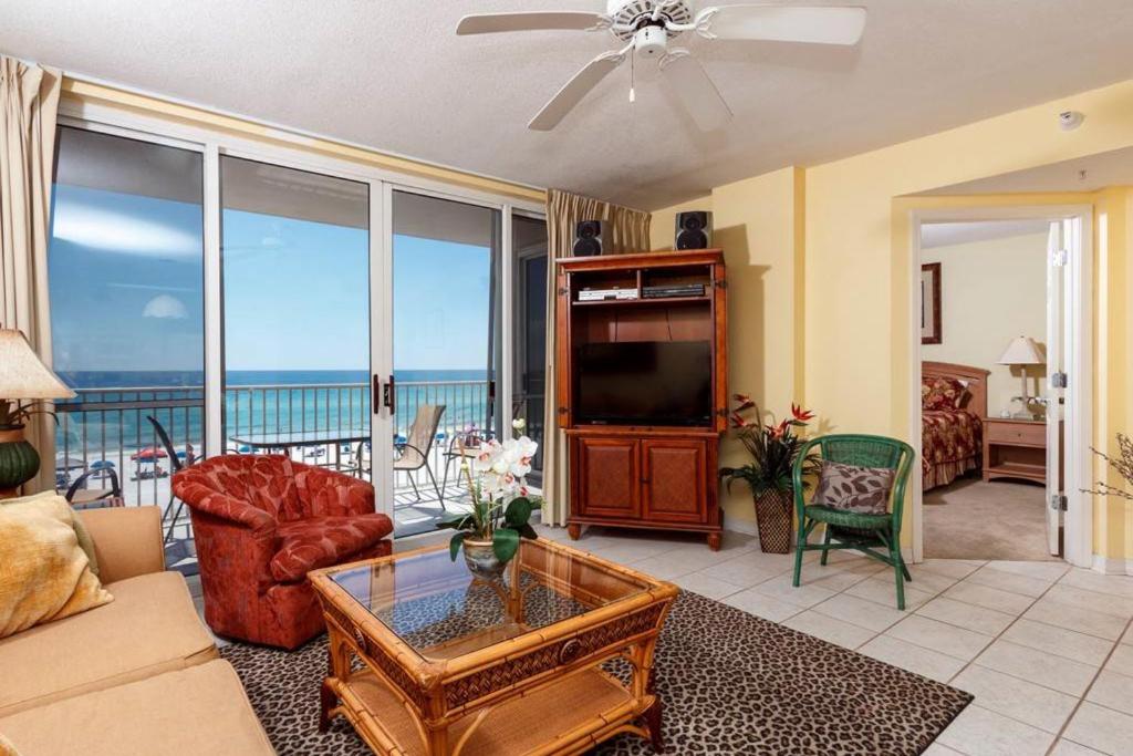 a living room with a couch and a television and a balcony at Island Princess Condos in Fort Walton Beach