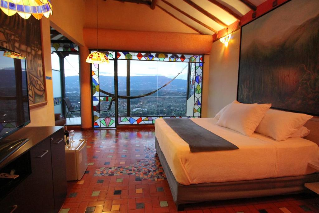 sypialnia z łóżkiem i dużym oknem w obiekcie Suites Arcoiris w mieście Villa de Leyva