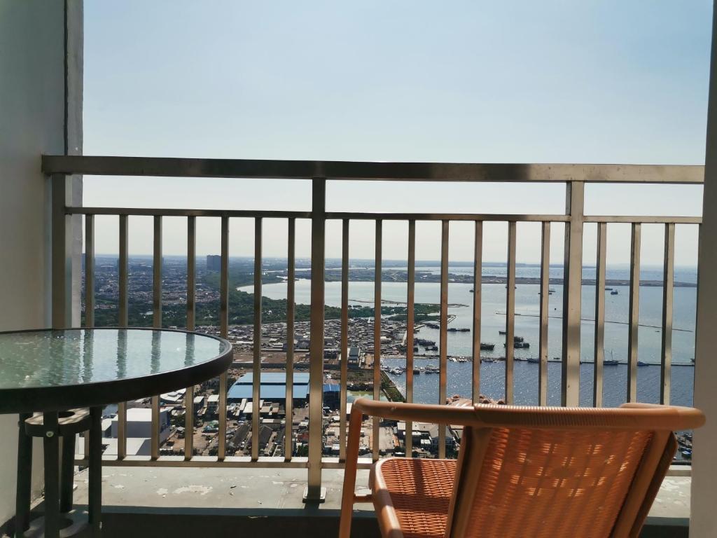 a balcony with a table and chairs and the ocean at 2 Bed Room Amazing Sea View Condo 80sqm Fast Internet in Jakarta