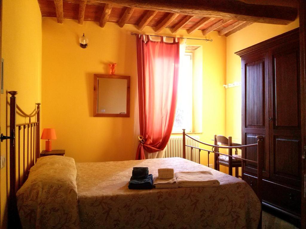 Schlafzimmer mit einem Bett mit einem roten Vorhang und einem Fenster in der Unterkunft La Coccinella di Silvia e Simone in Massarosa