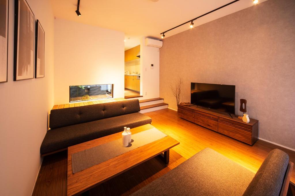a living room with a couch and a flat screen tv at ENGAWA Nakano in Tokyo
