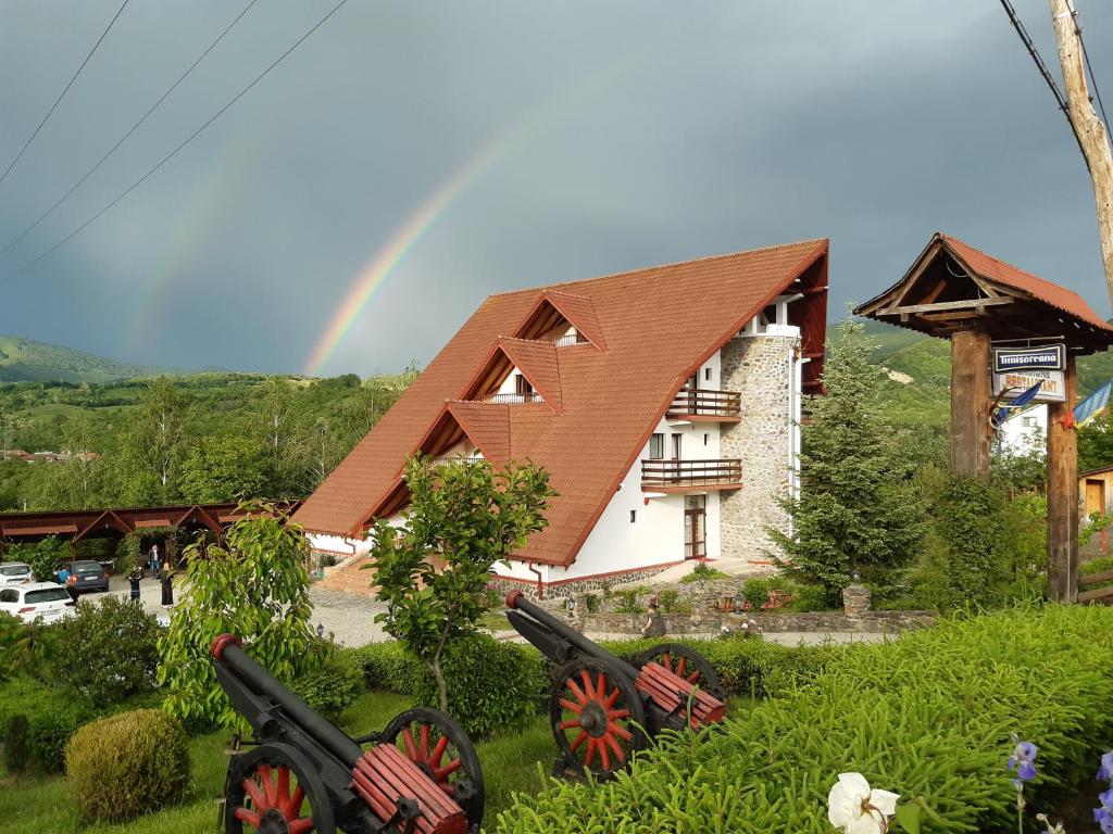 un arco iris frente a una casa con cañones en Belvedere, en Corbeni