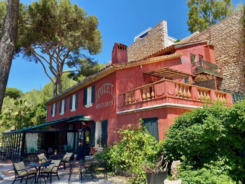 a red building with tables and chairs in front of it at Le Jardin d'Emile in Cassis
