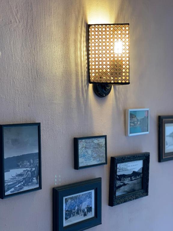 a wall with pictures and a light on it at Le Jardin d&#39;Emile in Cassis