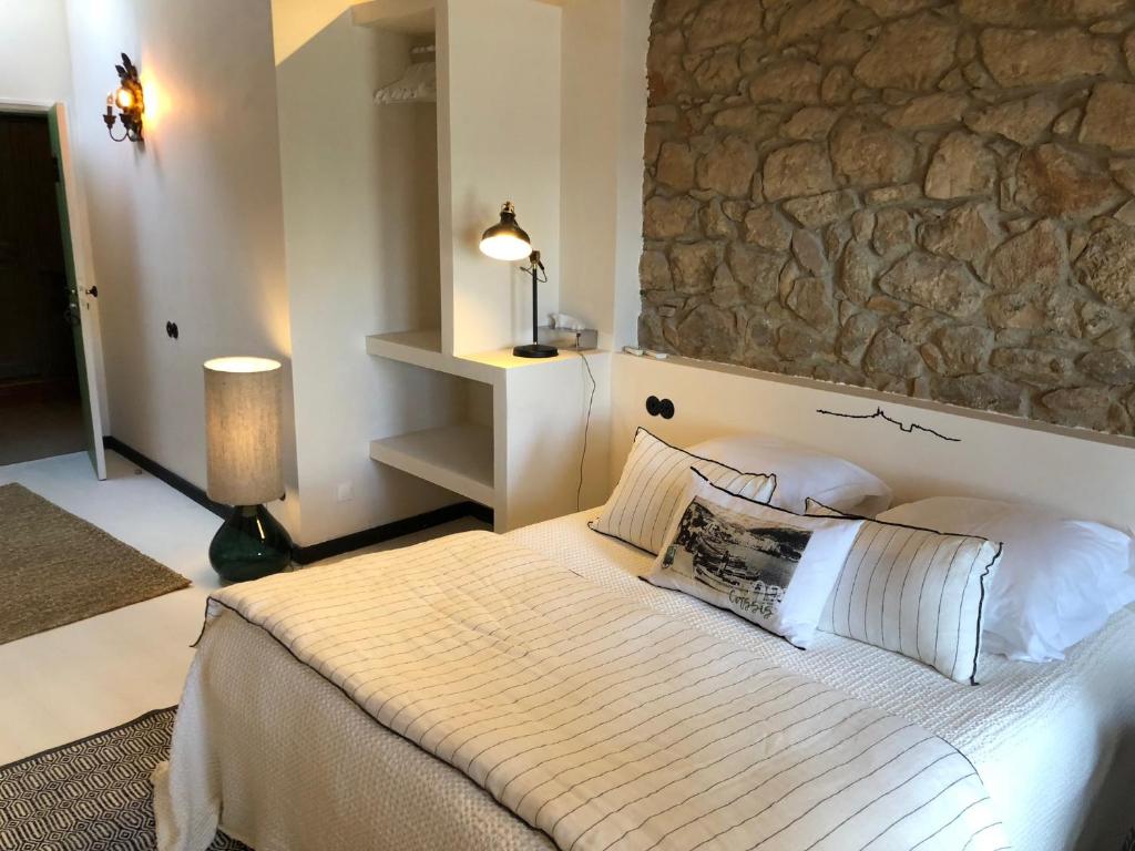 a bedroom with a bed with a stone wall at Le Jardin d&#39;Emile in Cassis
