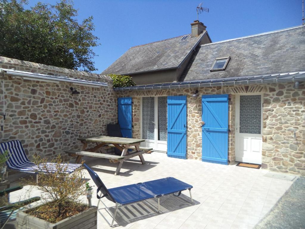 patio con porte blu e tavolo da picnic di Maison de vacances proche de la plage a Créances