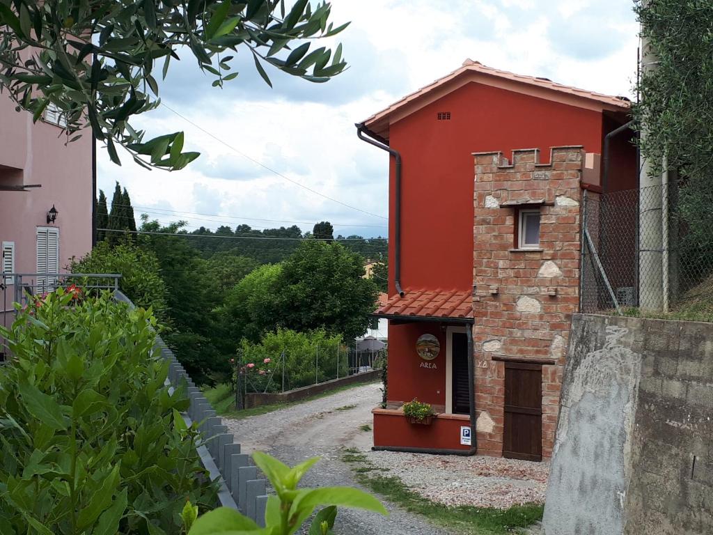 un edificio rojo en una carretera junto a una casa en L'ARCA affittacamere en Fucecchio