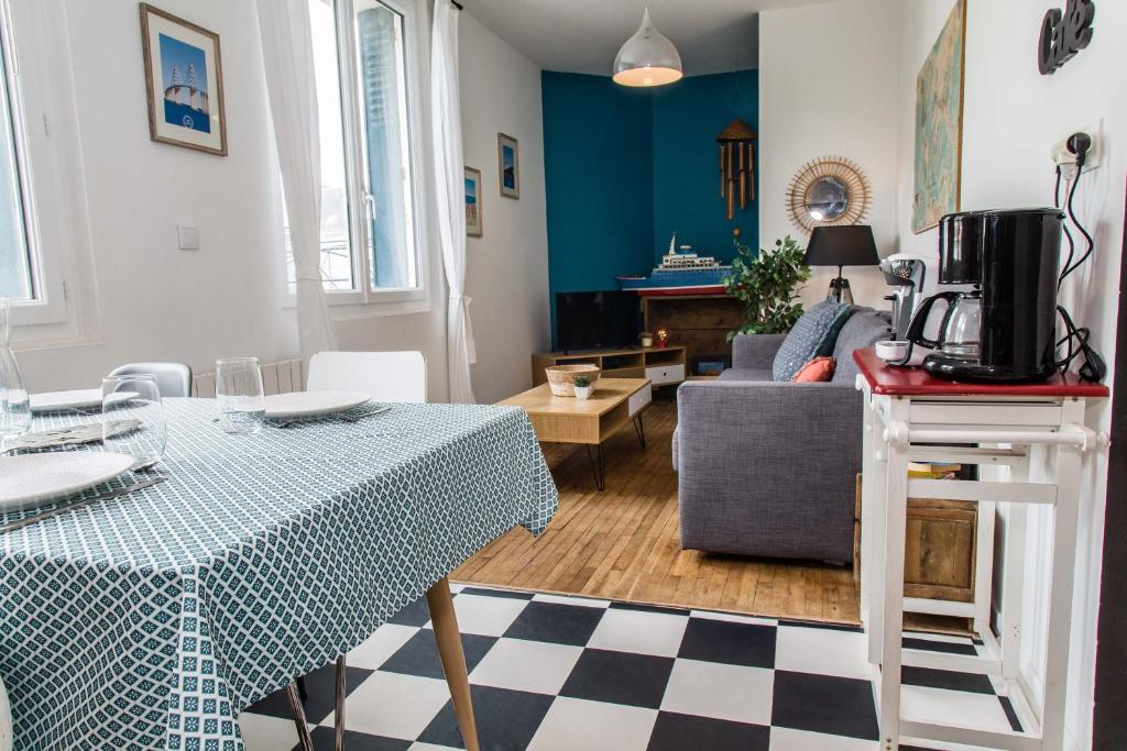 a living room with a table and a couch at Appartement 2 chambres hypercentre Saint Nazaire in Saint-Nazaire