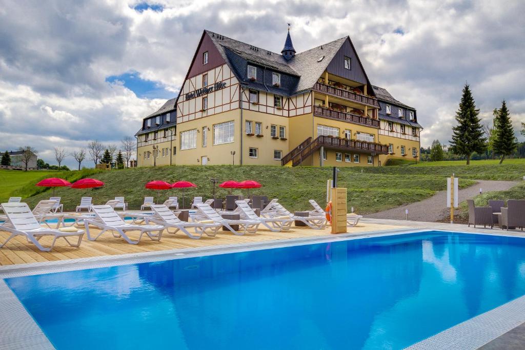 um grande edifício com piscina em frente a uma casa em Panorama Berghotel Wettiner Höhe em Seiffen