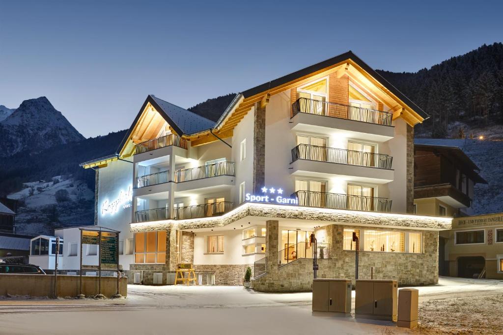 a hotel in the mountains at night with the lights on at Sport Garni Kapplerhof – Ischgl/Kappl in Kappl