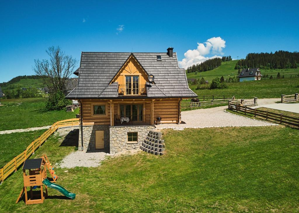 a house on a hill with a playground at Farmerska Chata in Czarna Góra