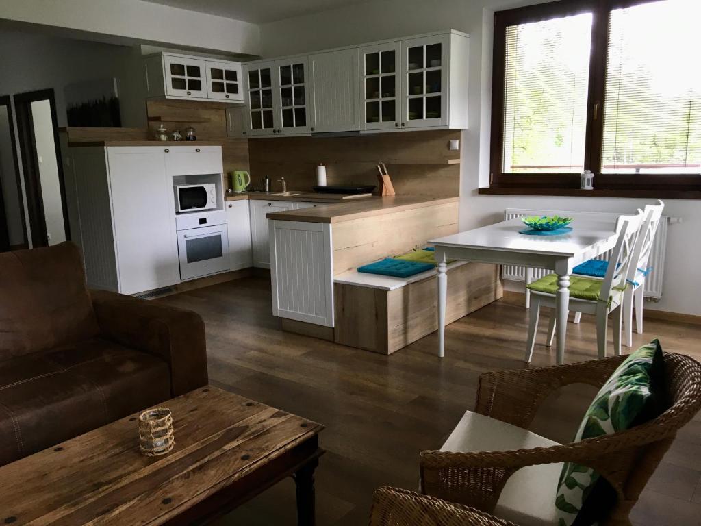 a kitchen and living room with a table and chairs at Apartman Kristof in Vysoke Tatry - Tatranska Lomnica.