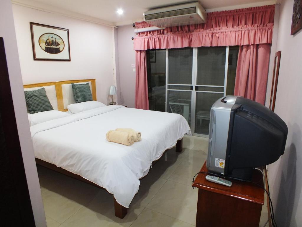 a bedroom with a bed and a tv in it at PR Place Hotel in Bangkok