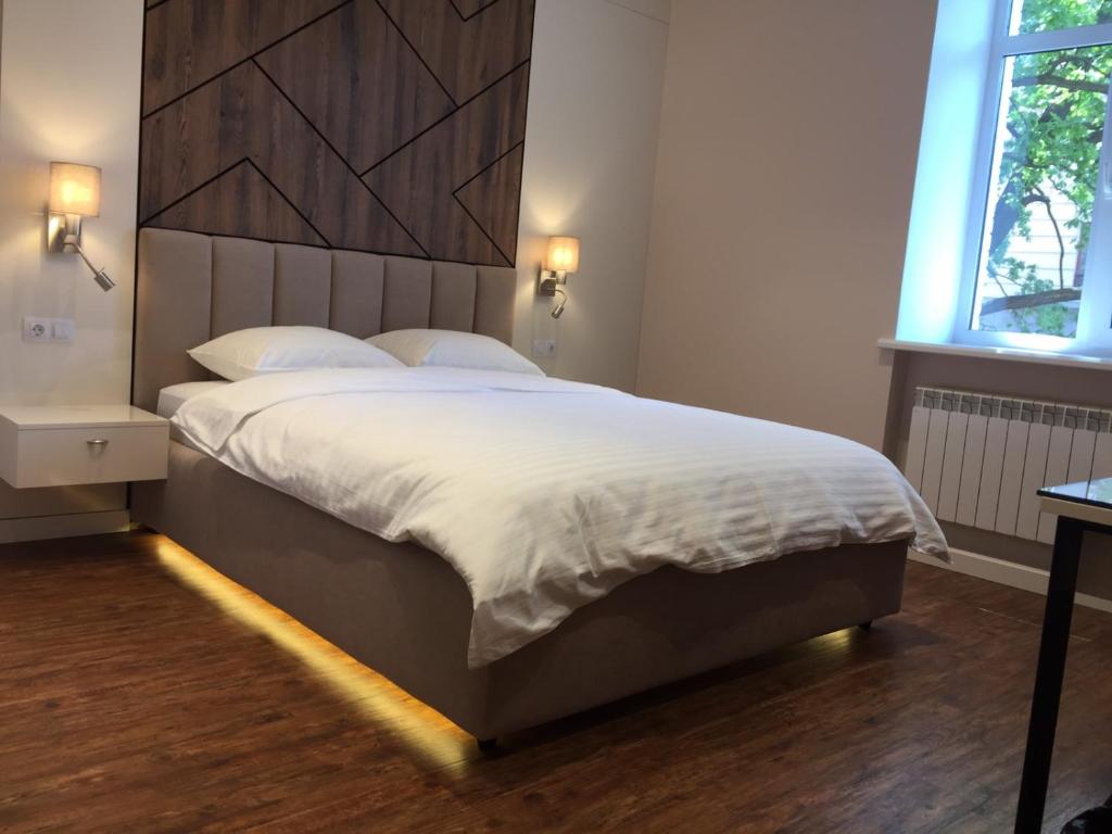 a bedroom with a large bed with a wooden headboard at Современный минимализм в центре Киева. in Kyiv