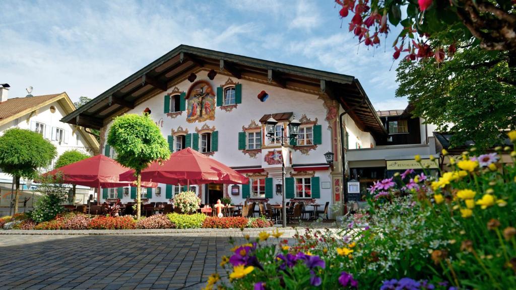 um edifício com guarda-chuvas e flores à sua frente em Hotel Alte Post em Oberammergau