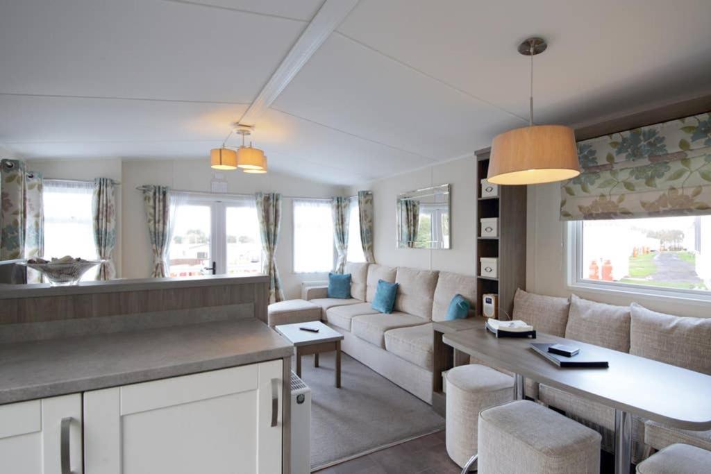ein Wohnzimmer mit einem Sofa und einem Tisch in der Unterkunft Edinburgh - Seton Sands-Cameo Caravan-Pet Friendly in Edinburgh