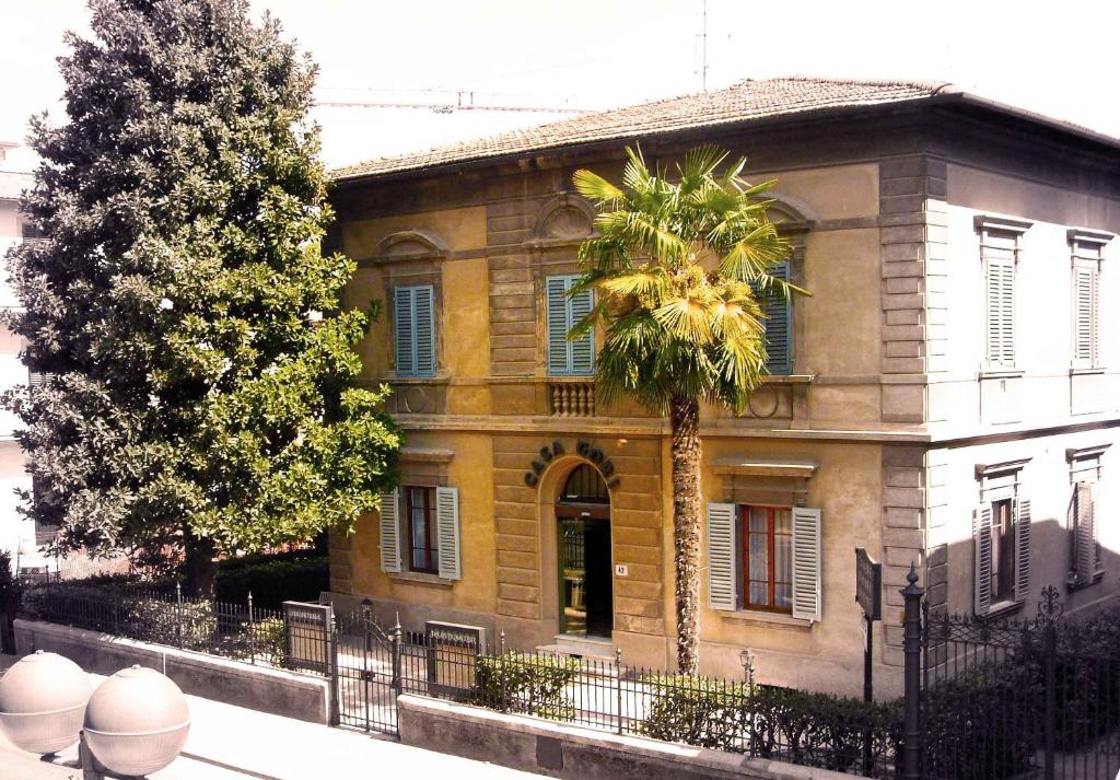 un antiguo edificio con una palmera delante de él en Casa Gori en Certaldo