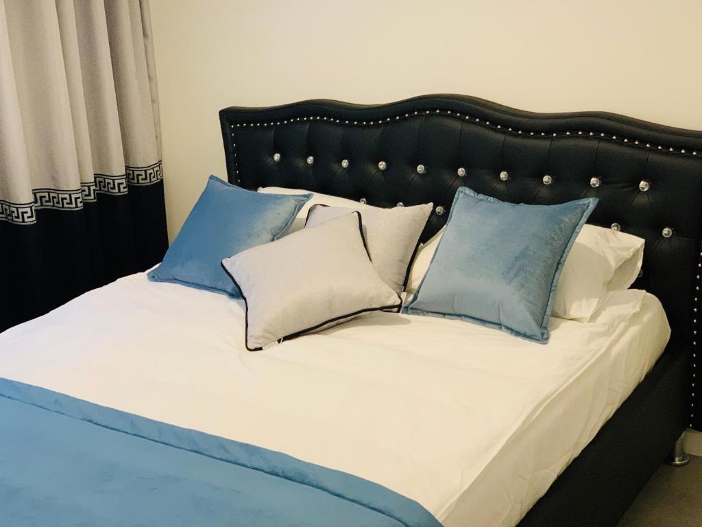 a bed with blue and white pillows on it at Apartament Jantarowe Zacisze Green in Jantar
