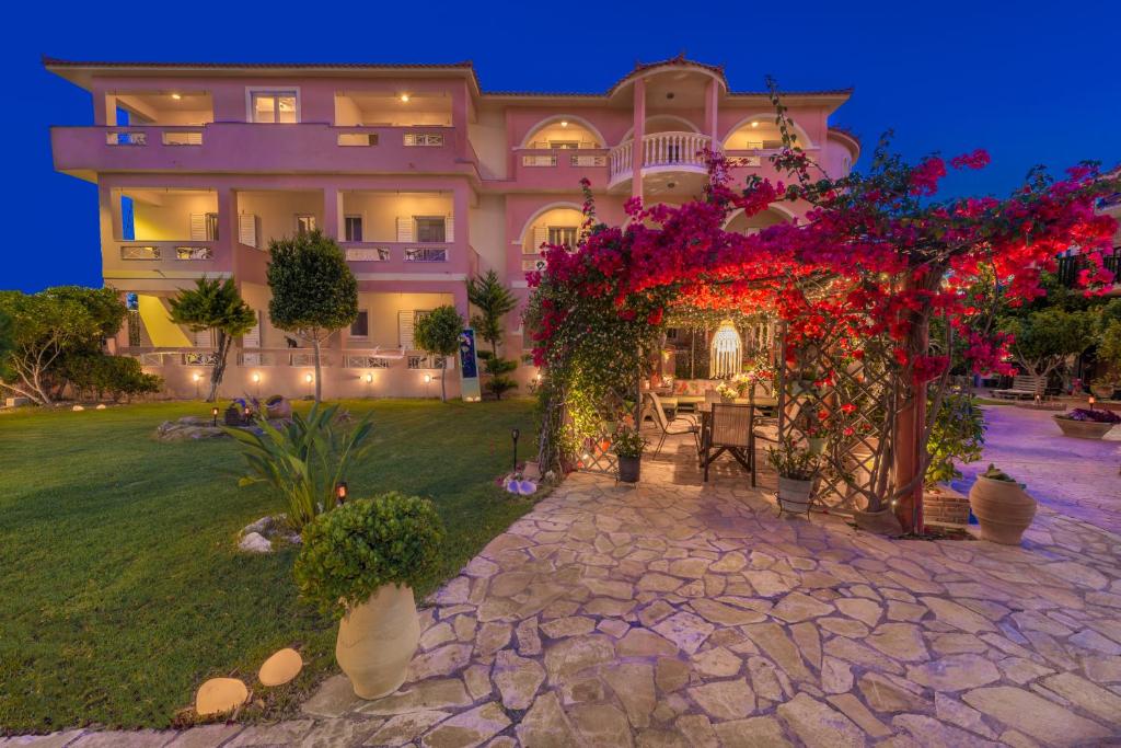 ein großes Haus mit Blumen davor in der Unterkunft Filoxenia Luxury Studios & Apartments in Zakynthos
