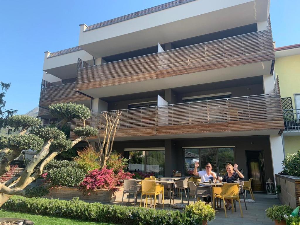 duas mulheres sentadas numa mesa em frente a um edifício em GardaBreak Rooms&Breakfast Holiday Apartments em Riva del Garda