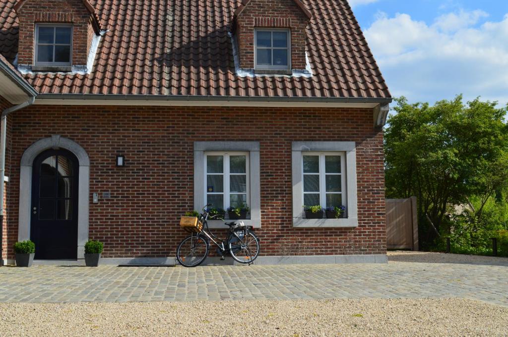 een fiets geparkeerd voor een bakstenen huis bij Maison Margriet in Tongeren