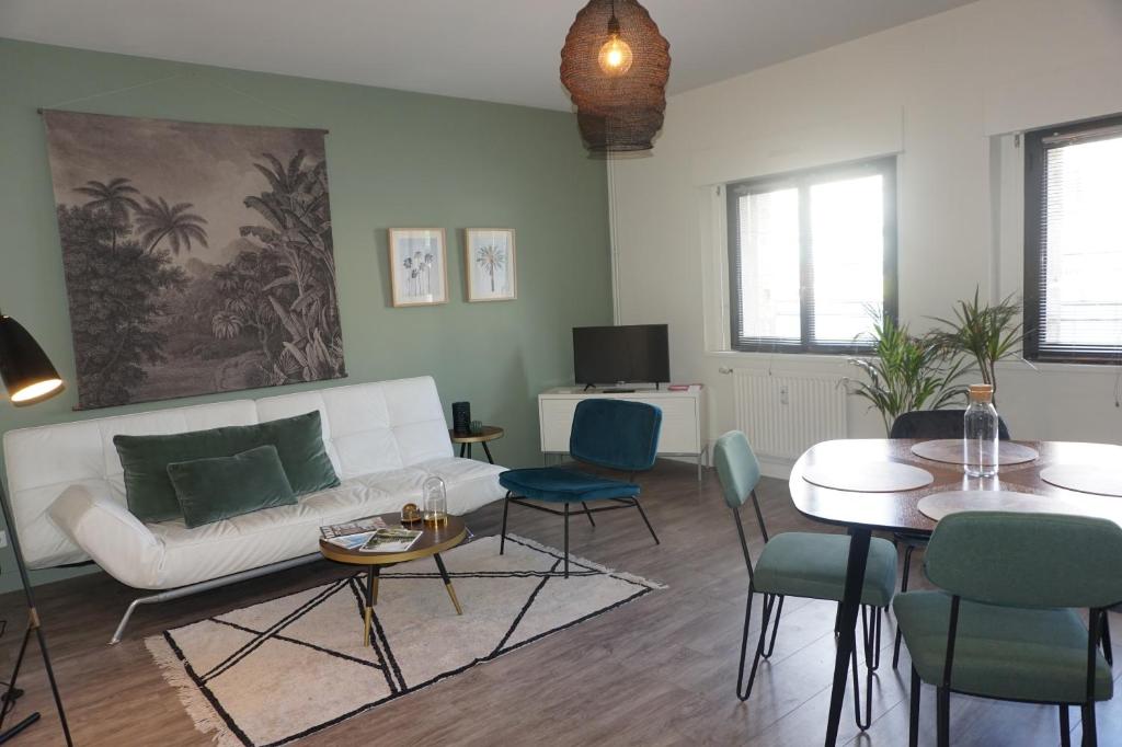 un salon avec un canapé blanc et une table dans l'établissement L'Eucalyptus, charmant T2 au cœur du centre ville, à Rennes