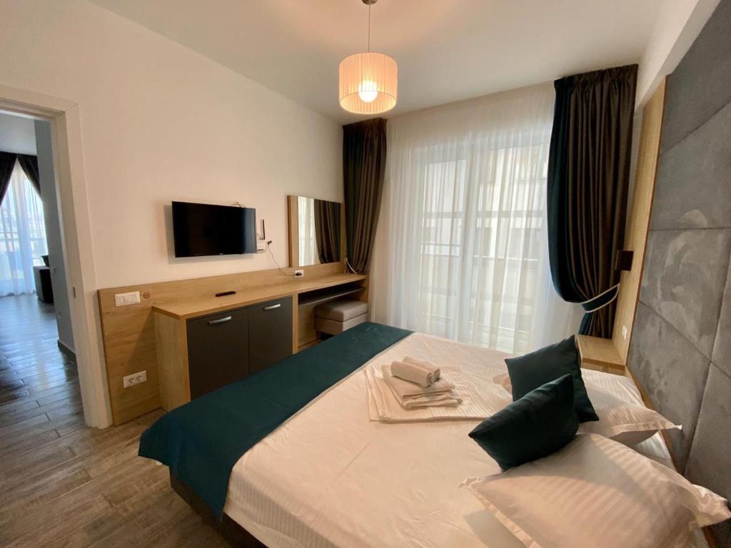 Habitación de hotel con cama y TV en Apartament Ella C&C Residence, en Mamaia Nord – Năvodari
