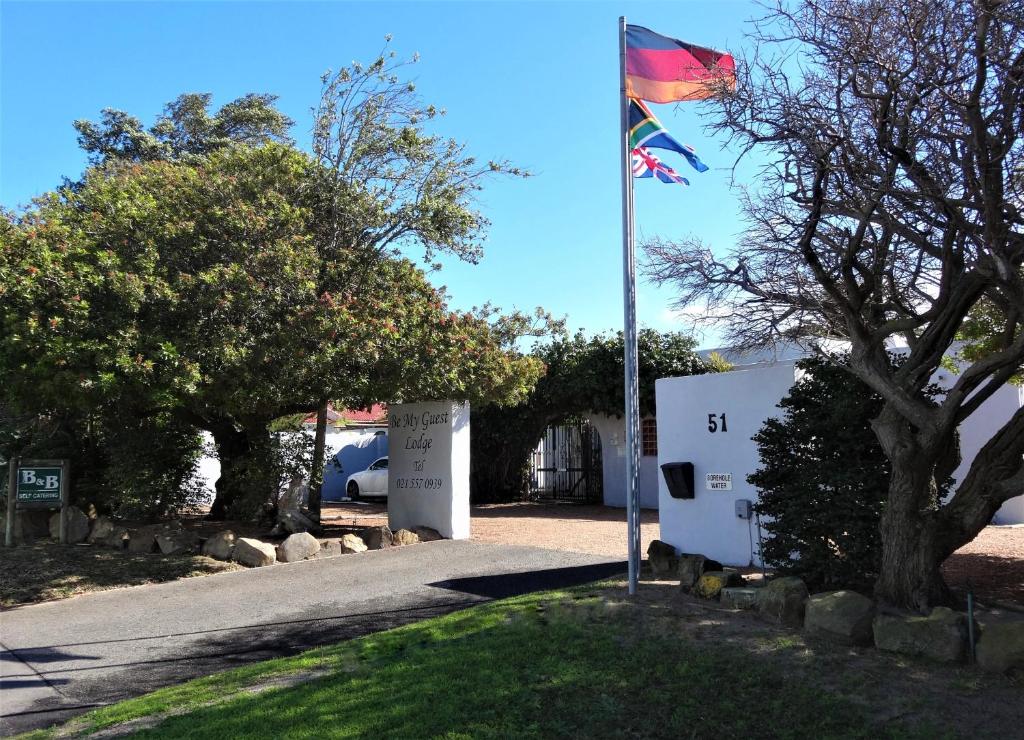 eine Flagge auf einer Stange neben einem Anhänger in der Unterkunft Be My Guest Lodge in Bloubergstrand