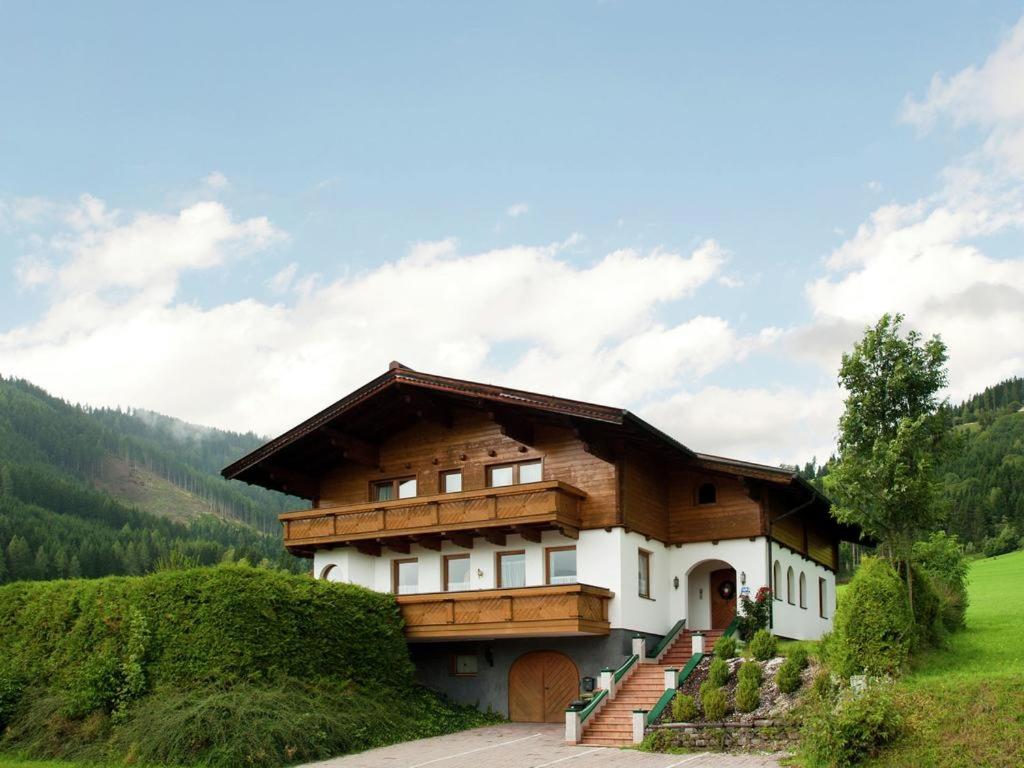 ein Haus auf einem Hügel mit einem Berg in der Unterkunft Appartements Maurer in Flachau