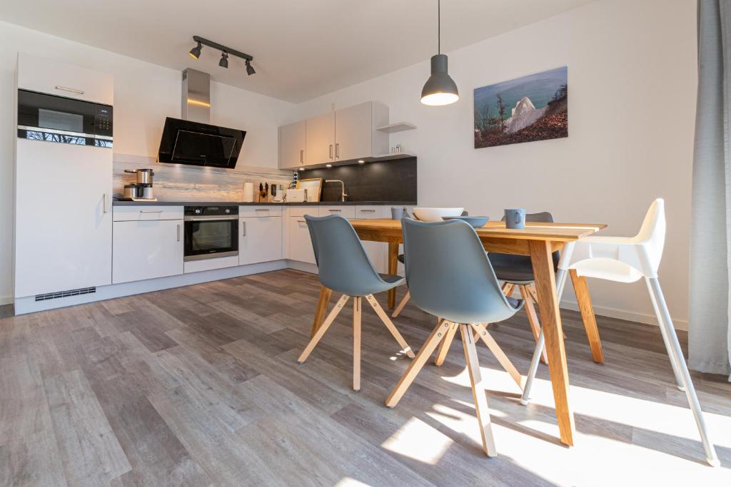 eine Küche und ein Esszimmer mit einem Holztisch und Stühlen in der Unterkunft Ferienwohnung Vergissmeinnicht in Ostseebad Sellin