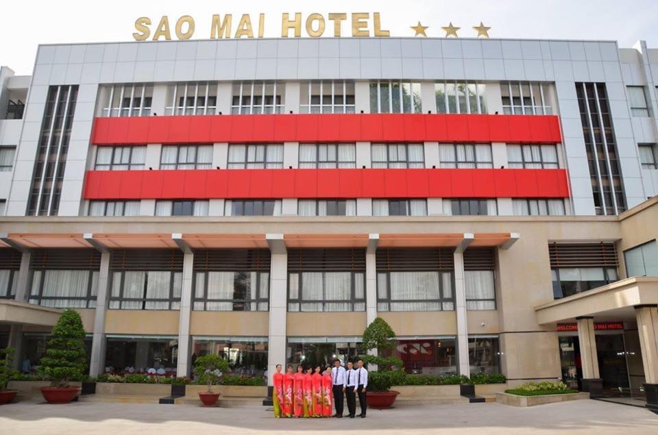 dos hombres parados frente a un hotel sao mol en KHÁCH SẠN SAO MAI en Cao Lãnh