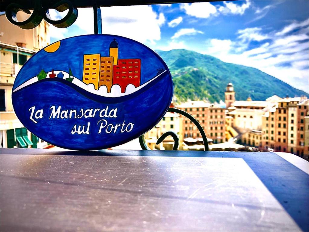 a sign on a table with a view of a city at La mansarda sul Porto in Camogli