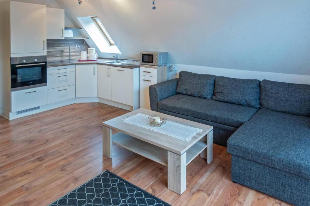 ein Wohnzimmer mit einem Sofa und einem Tisch in der Unterkunft Ferienwohnung Regina in Dornum