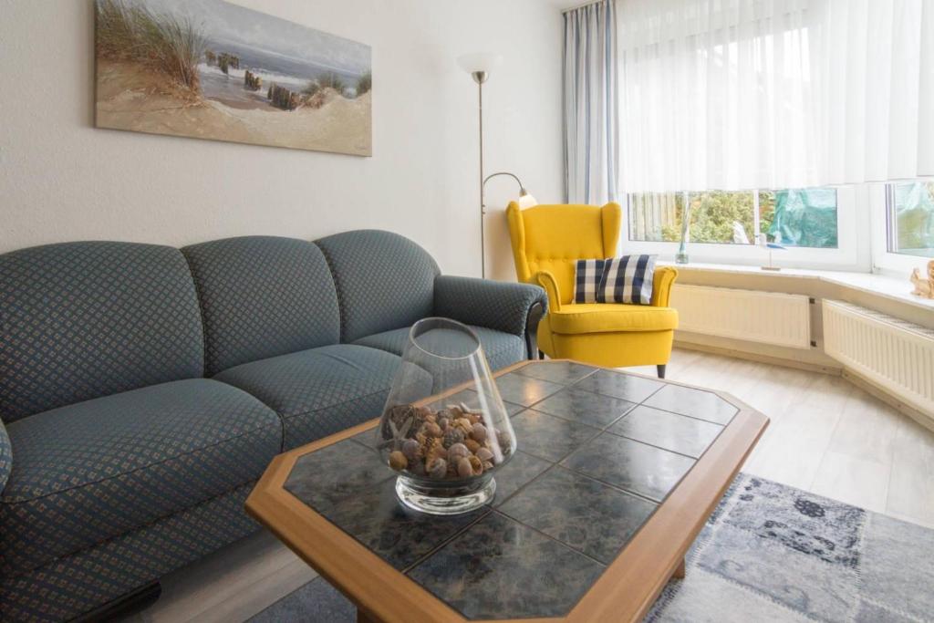 ドルヌマージールにあるFerienhaus Kormoranのリビングルーム(青いソファ、テーブル付)
