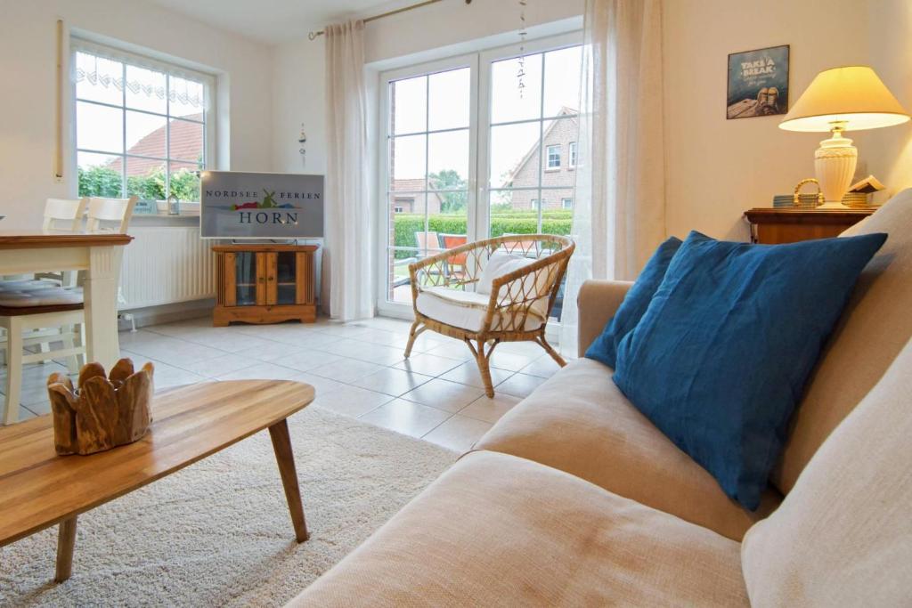 a living room with a couch and a table at Ferienhaus Strandruhe in Dornumersiel