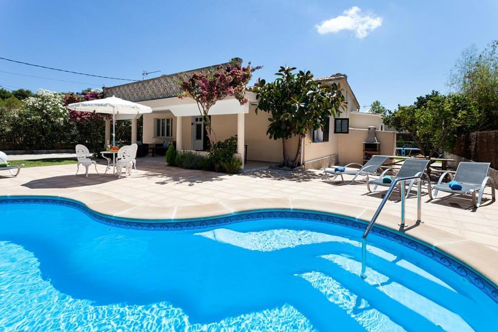 a swimming pool in front of a house at Villa Rosales in Alcudia