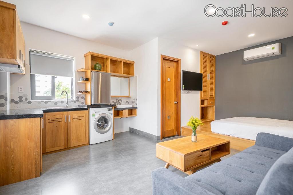 a living room with a couch and a bed and a kitchen at Coast House Boutique Hotel in Nha Trang