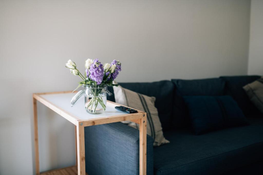 a vase of flowers on a table next to a couch at The Fullerton Arms in Ballintoy